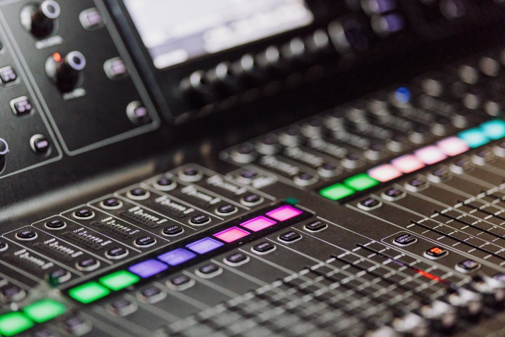 A detailed view of a professional audio mixing console with colorful LED indicators, ideal for music production environments.